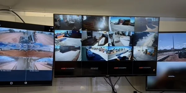 Multi-monitor CCTV control room displaying live feeds from Premium Grains rural sites, Fremantle
